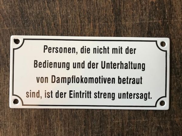 Emailleschild weiß, mit schwarzer Schrift  "Personen die nicht mit der Bedienung und  der Unterhaltung von Dampflokomotiven betraut sind, ist der Eintritt streng untersagt " ca. 17 x 8  cm.